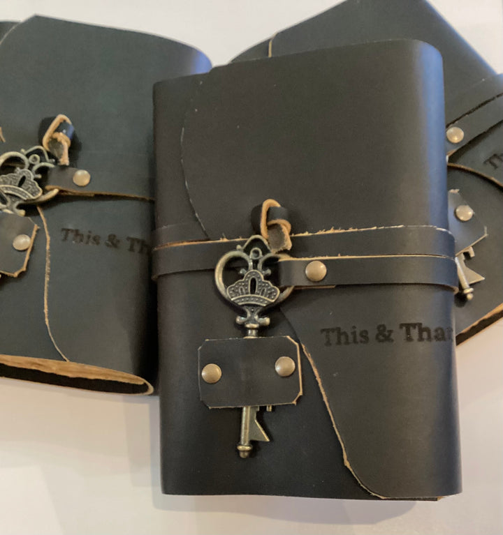 Small Black Leather Journal with Worn, Weathered Pages and Decorative Key
